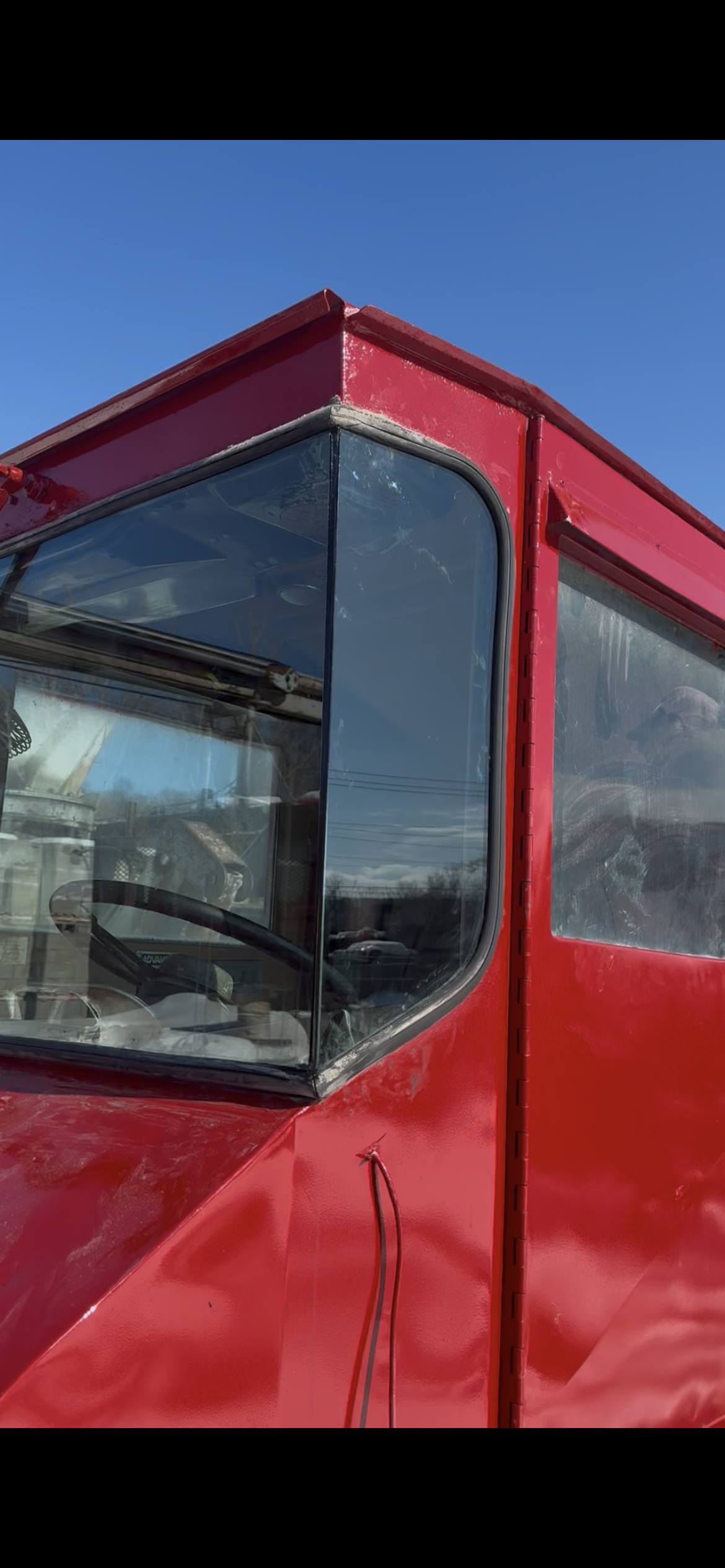 New side glass installed — red construction vehicle